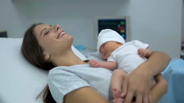 Happy family. Newborn baby sleeping in mother arms. Mom right after delivery in maternity hospital, Parturient woman holding new born child after birth labor Childbirth pregnant motherhood 4 K slow-mo