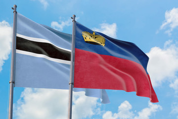 Liechtenstein and Botswana flags waving in the wind against white cloudy blue sky together. Diplomacy concept, international relations.