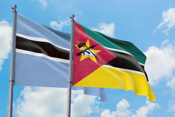 Mozambique and Botswana flags waving in the wind against white cloudy blue sky together. Diplomacy concept, international relations.