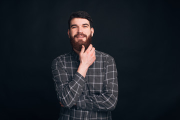 Fototapeta premium Studio portrait of a handsome man wearing a shirt on black background.