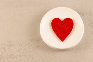 red heart symbol on a white plate. view from above. Romance and valentines day concept .copyspace for text