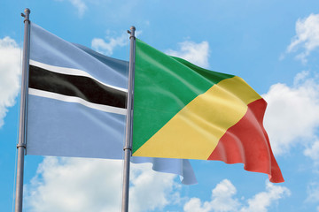 Republic Of The Congo and Botswana flags waving in the wind against white cloudy blue sky together. Diplomacy concept, international relations.