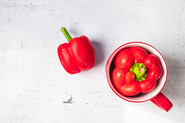 .Red bell peppers on white wooden background.