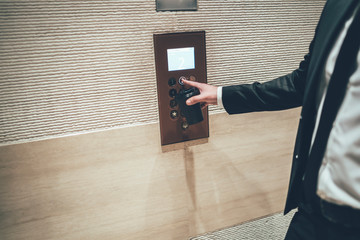 Man pressing number 2 on elevator panel