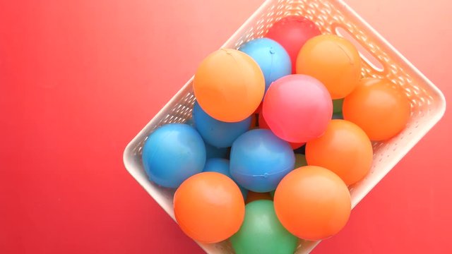 top view of colorful plastic ball on red background 