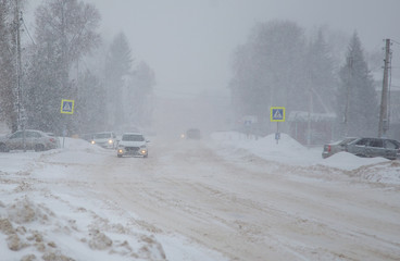 Winter, snow, blizzard, poor visibility on the road. Car during a blizzard on the road with...