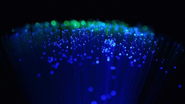 Fiber optics wire lamp, in the dark, with blurry bokeh, a symbol of high technology in online communication.