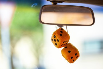 fuzzy dice haning from rear view mirror of classic car