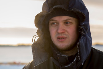 Portrait of a worker in protective workwear with a hood on his head