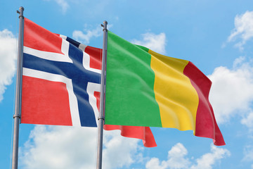 Mali and Bouvet Islands flags waving in the wind against white cloudy blue sky together. Diplomacy concept, international relations.