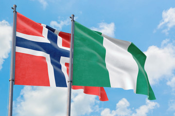 Nigeria and Bouvet Islands flags waving in the wind against white cloudy blue sky together. Diplomacy concept, international relations.