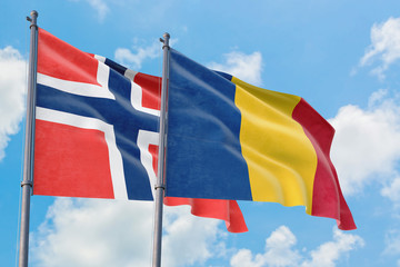 Romania and Bouvet Islands flags waving in the wind against white cloudy blue sky together. Diplomacy concept, international relations.