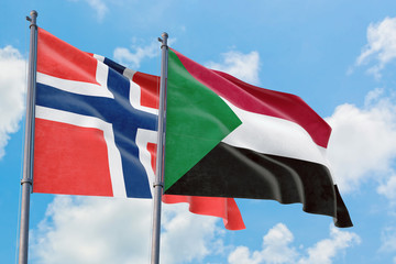 Sudan and Bouvet Islands flags waving in the wind against white cloudy blue sky together. Diplomacy concept, international relations.