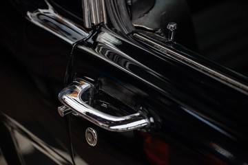 chrome door handle on black classic car