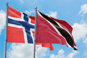 Trinidad And Tobago and Bouvet Islands flags waving in the wind against white cloudy blue sky together. Diplomacy concept, international relations.