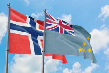 Tuvalu and Bouvet Islands flags waving in the wind against white cloudy blue sky together. Diplomacy concept, international relations.