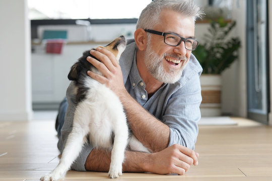 Man With Puppy Dog At Home