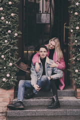 Happy couple in love sitting on stairs in city and smiling.