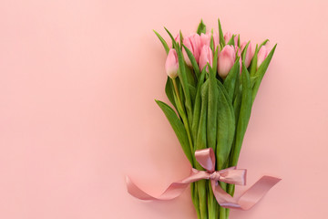 Fresh flower composition, bouquet of bi color tulips, pale pink and white gradient background. International Women's day, mother's day greeting concept. Copy space, close up, top view, flat lay.
