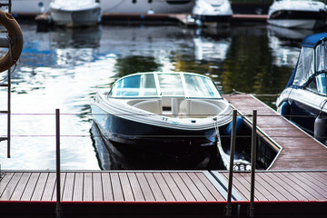 Fototapeta premium Small motor boat at anchor by rope in Replot pier