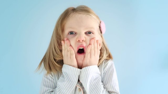 Portrait cute little girl looks and is surprised and happy to receive a surprise. The child learns something new and is surprised, cognitively and educated. Baby amazed. 