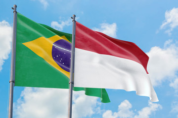 Indonesia and Brazil flags waving in the wind against white cloudy blue sky together. Diplomacy concept, international relations.