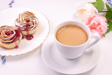 apple strudel in the form of a rose with a red apple and a cup of coffee