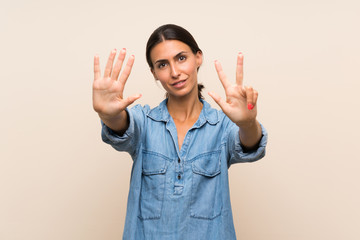 Young woman over isolated background counting eight with fingers