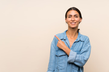 Young woman over isolated background pointing to the side to present a product