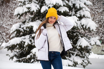 Portrait of a young happy woman on a background of a winter park