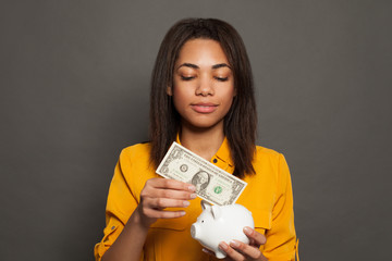 Black girl holding money box and 1 dollars banknote