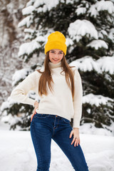 Portrait of a young happy woman on a background of a winter park