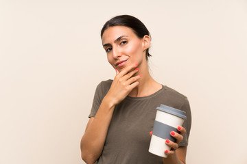 Naklejka premium Young woman holding a take away coffee thinking an idea
