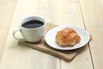 Croissant and coffee  isolated on wood table