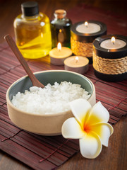 Obraz na płótnie Canvas Spa pure mineral sea salts with bottles of massage oil and aromatheray candles (Thai style)