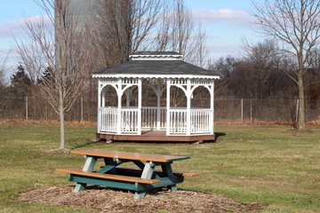 A peaceful view of the picnic table and white gazebo.