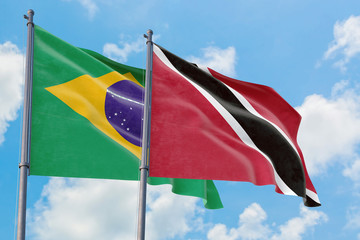 Trinidad And Tobago and Brazil flags waving in the wind against white cloudy blue sky together. Diplomacy concept, international relations.
