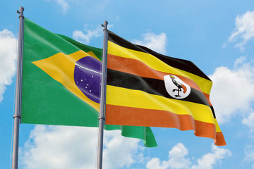 Uganda and Brazil flags waving in the wind against white cloudy blue sky together. Diplomacy concept, international relations.