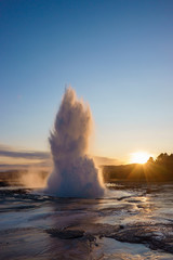 The Geysir water mist after eruption with blue skye during sunset in Iceland.