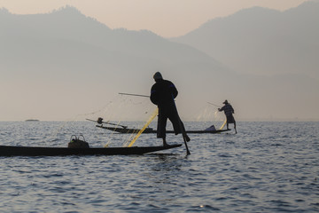 Naklejka premium The fisherman of the Inle Lake arranges fishing nets