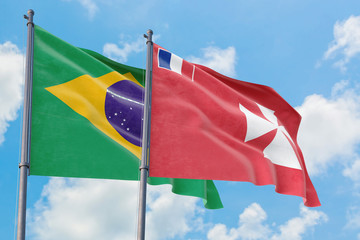 Wallis And Futuna and Brazil flags waving in the wind against white cloudy blue sky together. Diplomacy concept, international relations.