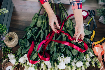 Fototapeta na wymiar Small business owner and beautiful florist woman preparing a white flower bouquet, enjoy working with plants and flowers. Botany, plants concept