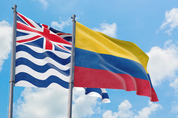 Colombia and British Indian Ocean Territory flags waving in the wind against white cloudy blue sky together. Diplomacy concept, international relations.