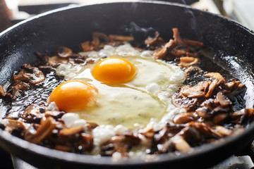 Fried mushrooms and eggs in a pan.