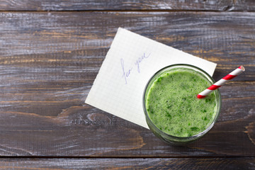 Healthy breakfast. Green smoothie with note "for you" on wooden table