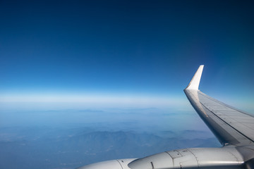 wing of airplane flying above clouds