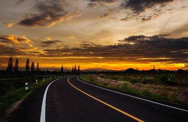 open road with beautiful sunset and golden sky.  Highland road.