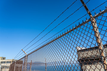 Fototapeta premium Metal fence with barbed wire on a restricted area