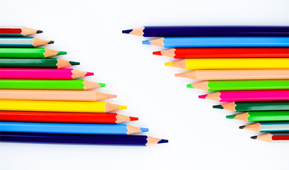 Collection of different colored pencil crayons arranged in two rows making a space for writing text
