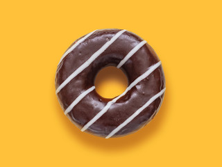 Doughnut in chocolate glaze on an orange background